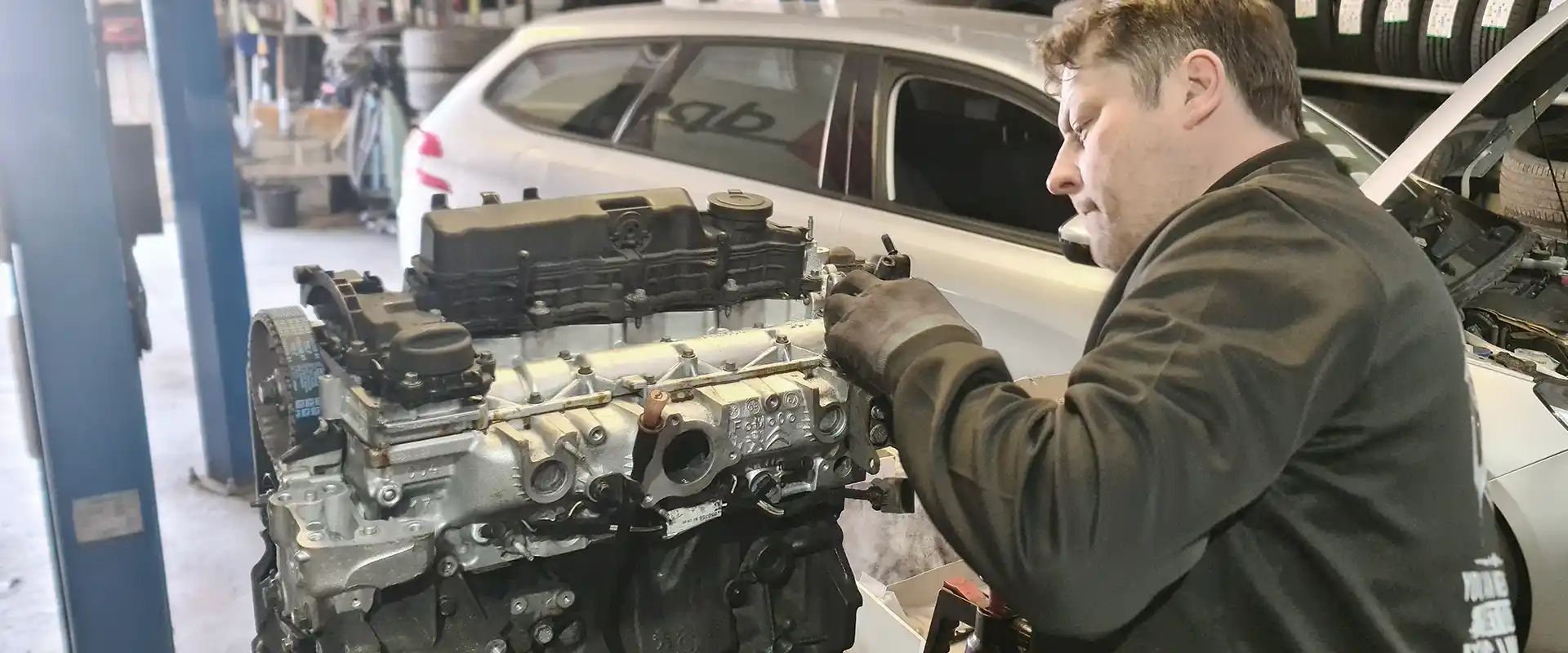 Mechanic repairing an extracted engine on a workbench