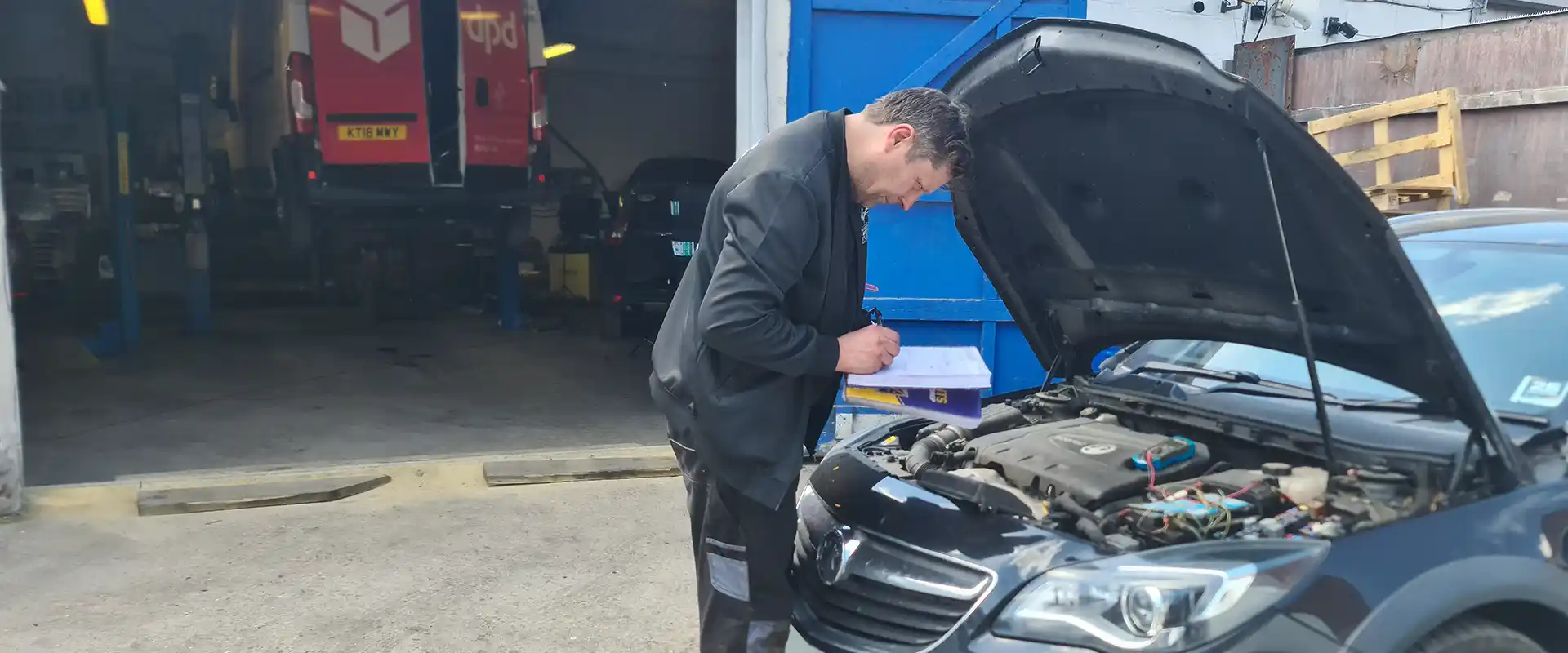 Mechanic reviewing engine checklist in front of garage